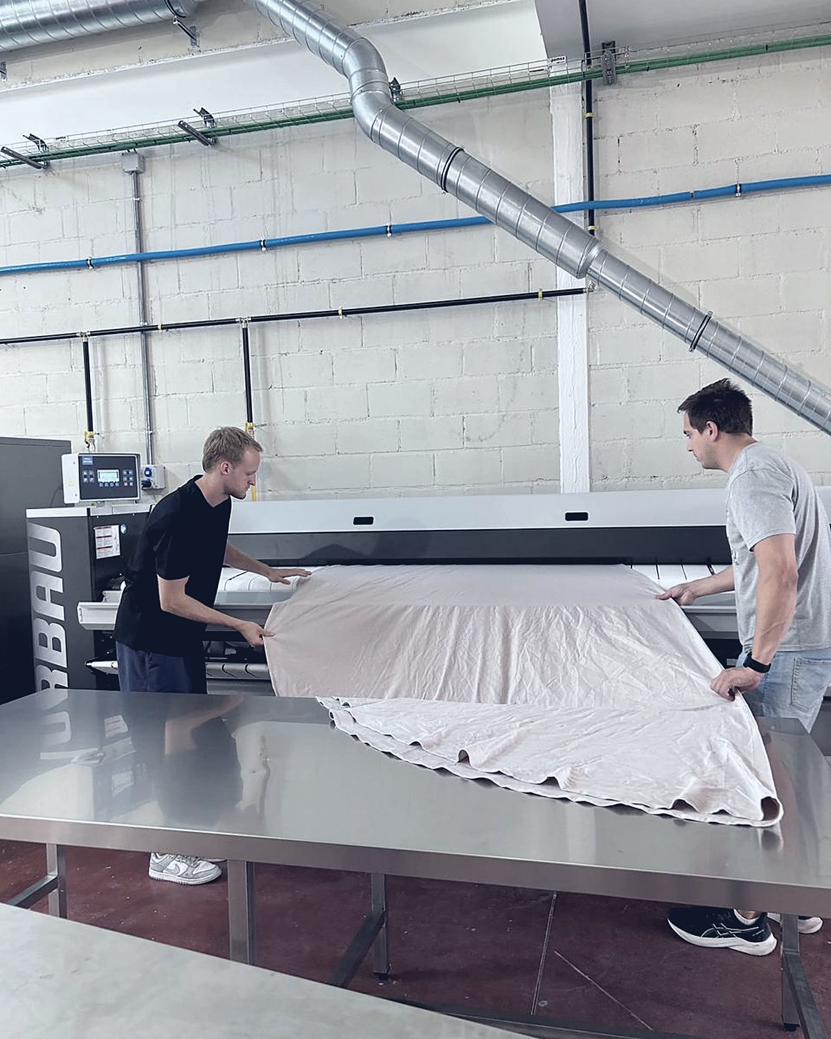 Equipo planchando textiles en la nave